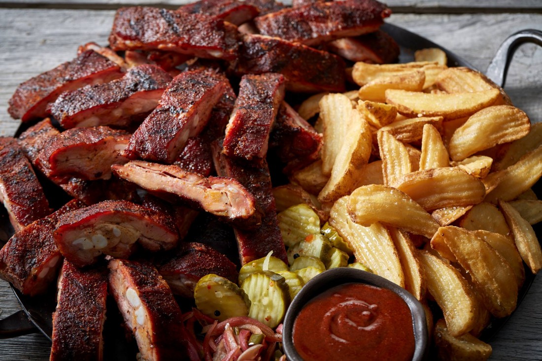Southside Rib Tips piled high with fries and pickles, a ramekin of ketchup on the side