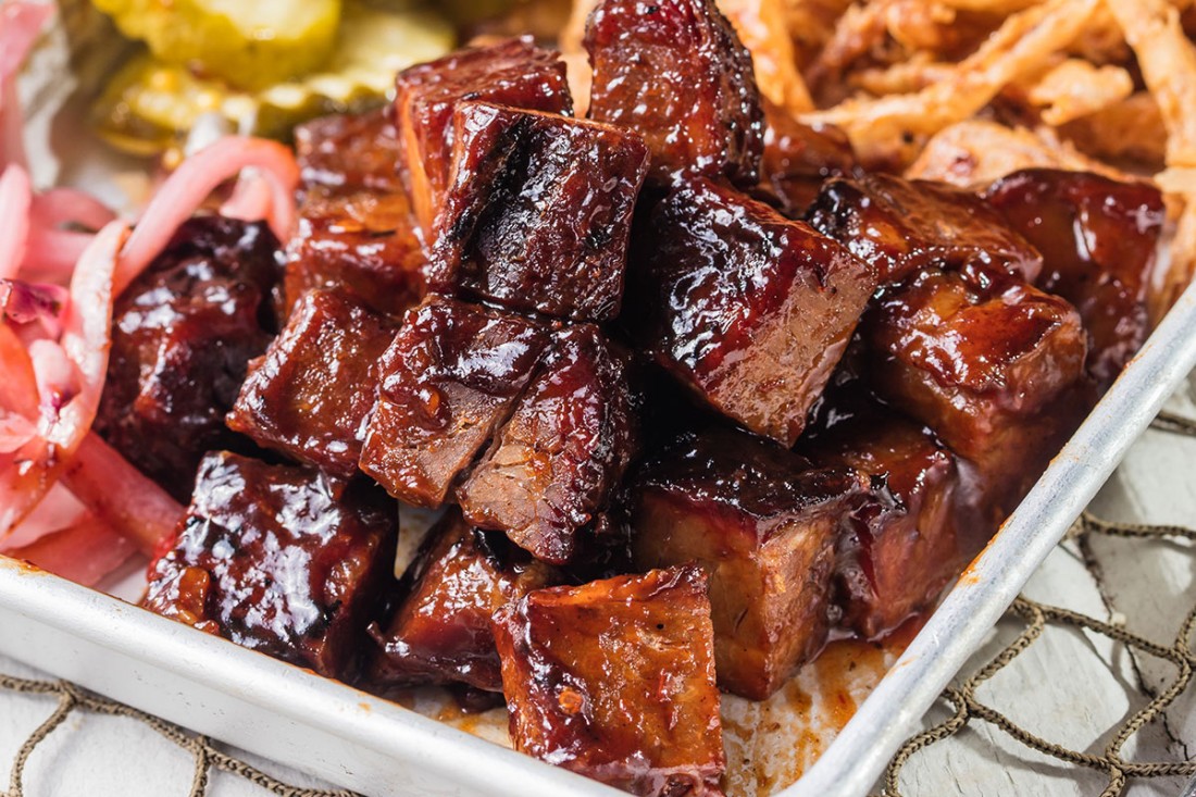 Famous Dave's BBQ Meat Burnt Ends with pickled onions and pickles on the side