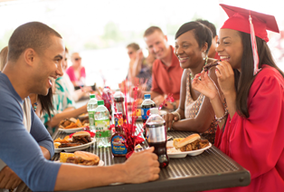 Graduates at a graduation party eating Famous Dave's BBQ