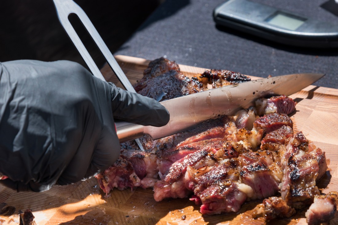 Hand of a Famous Dav's empployee slicing BBQ