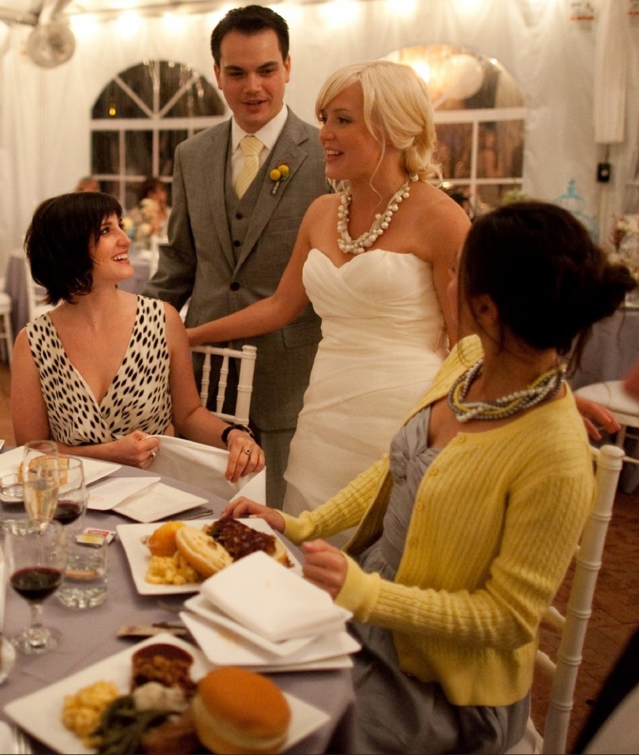 Bride and groom speak with guests as they eat Famous Dave's at their wedding